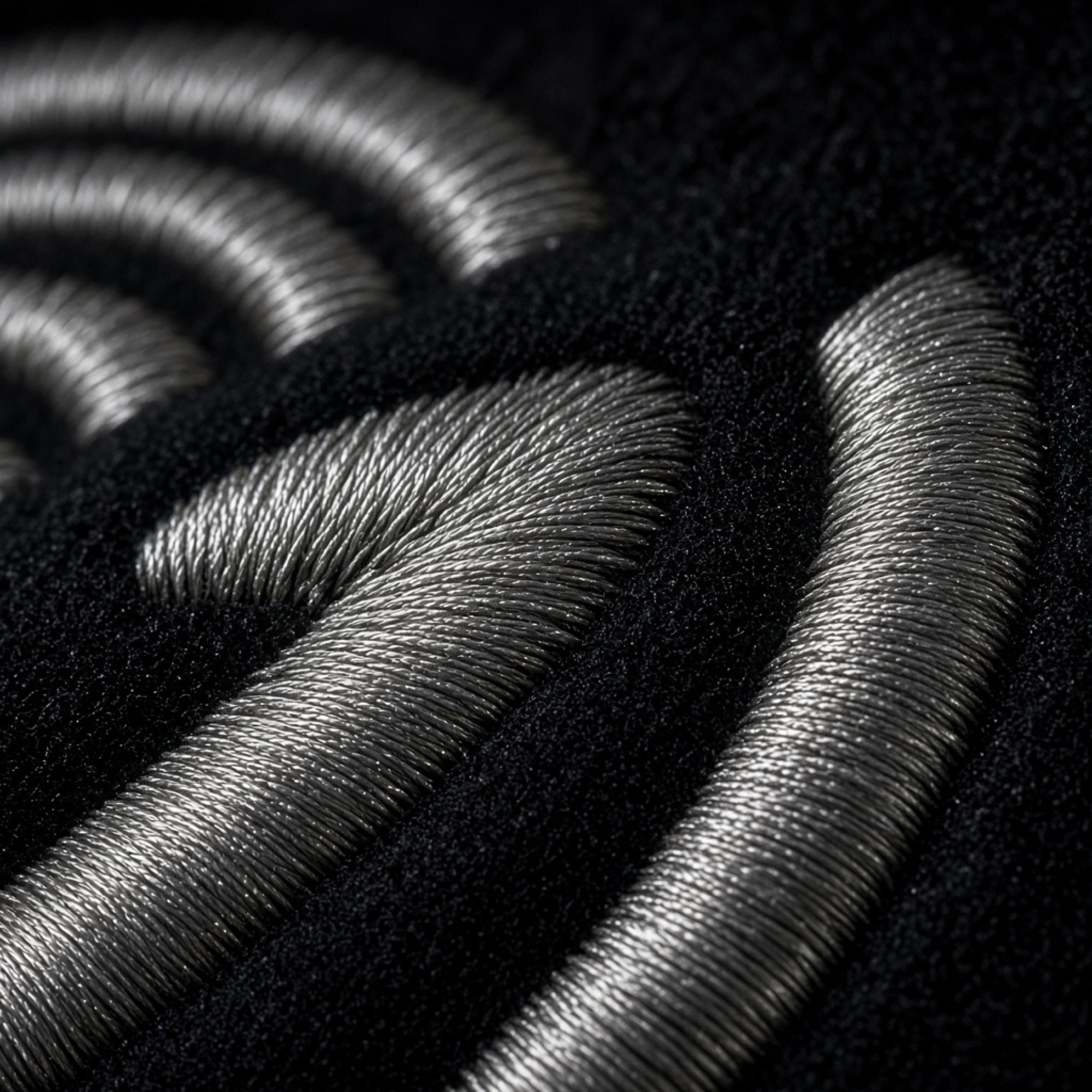 Metallic silver satin-stitch embroidery on black wool